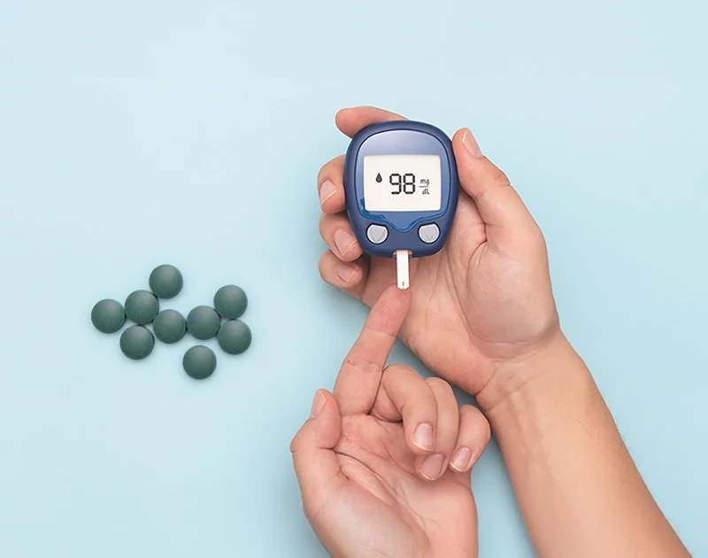 Glucometro con mano y espirulina en comprimidos